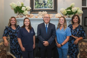 Group photo of doctor and staff in the waiting area of practice